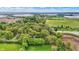 Aerial view of residential properties nestled amongst lush greenery with industrial buildings in the background at 2920 N Buck Creek Rd, Greenfield, IN 46140