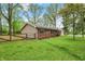 Backyard of this well-maintained home showcasing a lush lawn, wooden fence, and a combination of vinyl and brick siding at 2920 N Buck Creek Rd, Greenfield, IN 46140