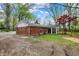 Backyard featuring a brick home, a sunroom, and a wooden fence under a canopy of trees at 2920 N Buck Creek Rd, Greenfield, IN 46140