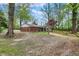 Backyard featuring a brick home with sunroom and wooden fence under green trees at 2920 N Buck Creek Rd, Greenfield, IN 46140