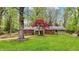 Charming backyard view of home featuring a lush lawn, mature trees, and a red maple at 2920 N Buck Creek Rd, Greenfield, IN 46140