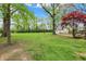 Green backyard with a large grassy area, a red maple tree and a detached garage at 2920 N Buck Creek Rd, Greenfield, IN 46140