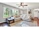 Cozy living room featuring large windows, a plush sofa, stylish rug, and view into the front yard and front entry at 2920 N Buck Creek Rd, Greenfield, IN 46140