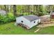 View of a white outbuilding or shed with a dark roof, surrounded by lush greenery and trees at 2920 N Buck Creek Rd, Greenfield, IN 46140