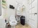 Cozy bathroom features a toilet, sink, open storage shelves, grab bar, and a trash can for convenience at 306 W Clyde St, Frankton, IN 46044