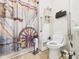 Full bathroom features a rustic shower curtain, toilet, wall storage and grab bar for accessibility at 306 W Clyde St, Frankton, IN 46044