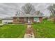 Quaint brick home with a ramp leading to the front door and a spacious yard with dandelions at 306 W Clyde St, Frankton, IN 46044