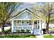 Charming bungalow featuring light blue siding, a cozy front porch, and beautifully landscaped yard at 316 S Arlington Ave, Indianapolis, IN 46219