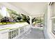 Comfortable covered porch with swing, railing, and views of a tree-lined street at 316 S Arlington Ave, Indianapolis, IN 46219