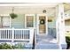 Inviting covered porch with hanging plants, seating area, and decorative wreath on front door at 316 S Arlington Ave, Indianapolis, IN 46219