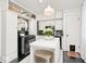 Bright kitchen with white cabinetry, black appliances, and a central island with additional seating at 316 S Arlington Ave, Indianapolis, IN 46219
