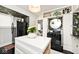 Well-lit kitchen featuring black appliances, a white kitchen island, and unique floral wallpaper at 316 S Arlington Ave, Indianapolis, IN 46219