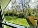 Window view of expansive backyard with lush green lawn, mature trees and wooden fence at 3514 Carson Ave, Indianapolis, IN 46227