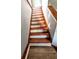 Angled, upward view of wooden staircase with white risers, showcasing the home's interior architecture at 3514 Carson Ave, Indianapolis, IN 46227