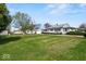 Expansive front yard of the property, featuring a well-kept lawn, detached garage, and mature trees at 3737 Forest Ter, Anderson, IN 46013