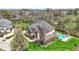 Aerial view of a brick home with a pool, professional landscaping, and a large yard in a residential neighborhood at 3940 Woodcrest Ct, Westfield, IN 46062