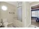 Well-lit bathroom with an octagonal window, tub, and tiled surround at 3940 Woodcrest Ct, Westfield, IN 46062