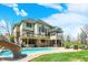 Spacious home with multiple decks and patios overlooking a backyard pool, lounge area, and manicured lawn at 3940 Woodcrest Ct, Westfield, IN 46062