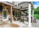 Inviting covered patio featuring stone accents, wood furniture, and French doors leading inside at 3940 Woodcrest Ct, Westfield, IN 46062