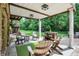Cozy outdoor patio with stone accents, wood furniture, and lush green landscaping, perfect for entertaining at 3940 Woodcrest Ct, Westfield, IN 46062