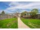 The backyard features a well-manicured lawn and a paved pathway leading to an outdoor seating area at 4203 Main St, Anderson, IN 46013