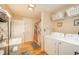 Bathroom and laundry area with sink, washer, dryer, linen closet, and decorative accents at 4203 Main St, Anderson, IN 46013