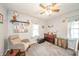 Bedroom with light blue walls, carpet floors, a crib, and a window with light blue curtains at 4203 Main St, Anderson, IN 46013