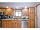 Well-lit kitchen with wood cabinets, modern dishwasher, and plenty of counter space at 4203 Main St, Anderson, IN 46013