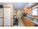 Galley kitchen featuring wood cabinets, updated stainless steel appliances, and a breakfast bar area at 4203 Main St, Anderson, IN 46013