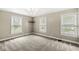 A bright bedroom featuring three windows and neutral colored walls at 4575 N Guilford Ave, Indianapolis, IN 46205