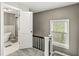 The upper hallway features a view of a bathroom with a modern soaking tub and a window with natural light at 4575 N Guilford Ave, Indianapolis, IN 46205