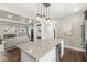 Kitchen island featuring granite countertop, seating, and open to the living room at 4575 N Guilford Ave, Indianapolis, IN 46205