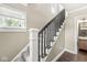 The home features a staircase with carpeted steps and a contrasting black railing, with a view of a nearby washroom at 4575 N Guilford Ave, Indianapolis, IN 46205