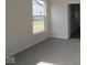 Cozy bedroom with a large window offering outdoor views and neutral carpeting at 5052 Carmine St, Brownsburg, IN 46112