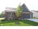 Charming brick home featuring a manicured lawn and attached two-car garage, enhancing curb appeal at 5052 Carmine St, Brownsburg, IN 46112