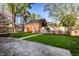Charming backyard featuring stone patio, a brick outbuilding, and lush lawn with a picket fence at 5130 N Washington Blvd, Indianapolis, IN 46205