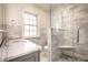 Bathroom featuring marble tiles, glass-enclosed shower, vanity, and classic finishes at 5130 N Washington Blvd, Indianapolis, IN 46205