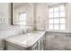 Bright bathroom featuring a marble countertop, grey cabinetry, and window at 5130 N Washington Blvd, Indianapolis, IN 46205