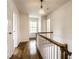 Hallway featuring hardwood floors, white walls, and a staircase with wood railing at 5130 N Washington Blvd, Indianapolis, IN 46205