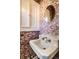 Unique powder room with patterned wallpaper, classic vanity, and a decorative round mirror at 5130 N Washington Blvd, Indianapolis, IN 46205