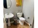 Powder room featuring a pedestal sink, toilet, round mirror, and decorative artwork on the wall at 5773 Station Hill Dr, Avon, IN 46123