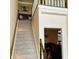 Carpeted staircase with white railing and dark wood trim leads to the second floor of this home at 5773 Station Hill Dr, Avon, IN 46123