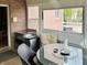 Bright sunroom featuring a glass top table with chairs, an outdoor brick view, and multiple windows at 5773 Station Hill Dr, Avon, IN 46123