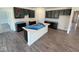 Modern kitchen with an island, dark cabinets, stainless steel sink and wood flooring at 5924 Trichel Dr, Greenwood, IN 46143
