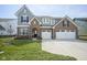 Charming two-story home with brick and gray siding, attached two-car garage, and well-manicured lawn at 613 Waterford Ln, Westfield, IN 46074