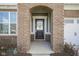 Close-up of front entry with brick archway and black front door with glass window at 613 Waterford Ln, Westfield, IN 46074