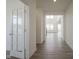 Bright hallway featuring hardwood floors, white trim, and a glass-paneled door to another room at 613 Waterford Ln, Westfield, IN 46074