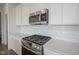 Well-equipped kitchen featuring stainless steel appliances, granite countertops, and white cabinets at 613 Waterford Ln, Westfield, IN 46074