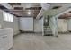A basement area featuring unfinished walls, open ceiling framework and a staircase at 620 S Irvington Ave, Indianapolis, IN 46219