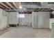 Unfinished basement with concrete flooring and walls featuring open ceiling framework and access panels at 620 S Irvington Ave, Indianapolis, IN 46219